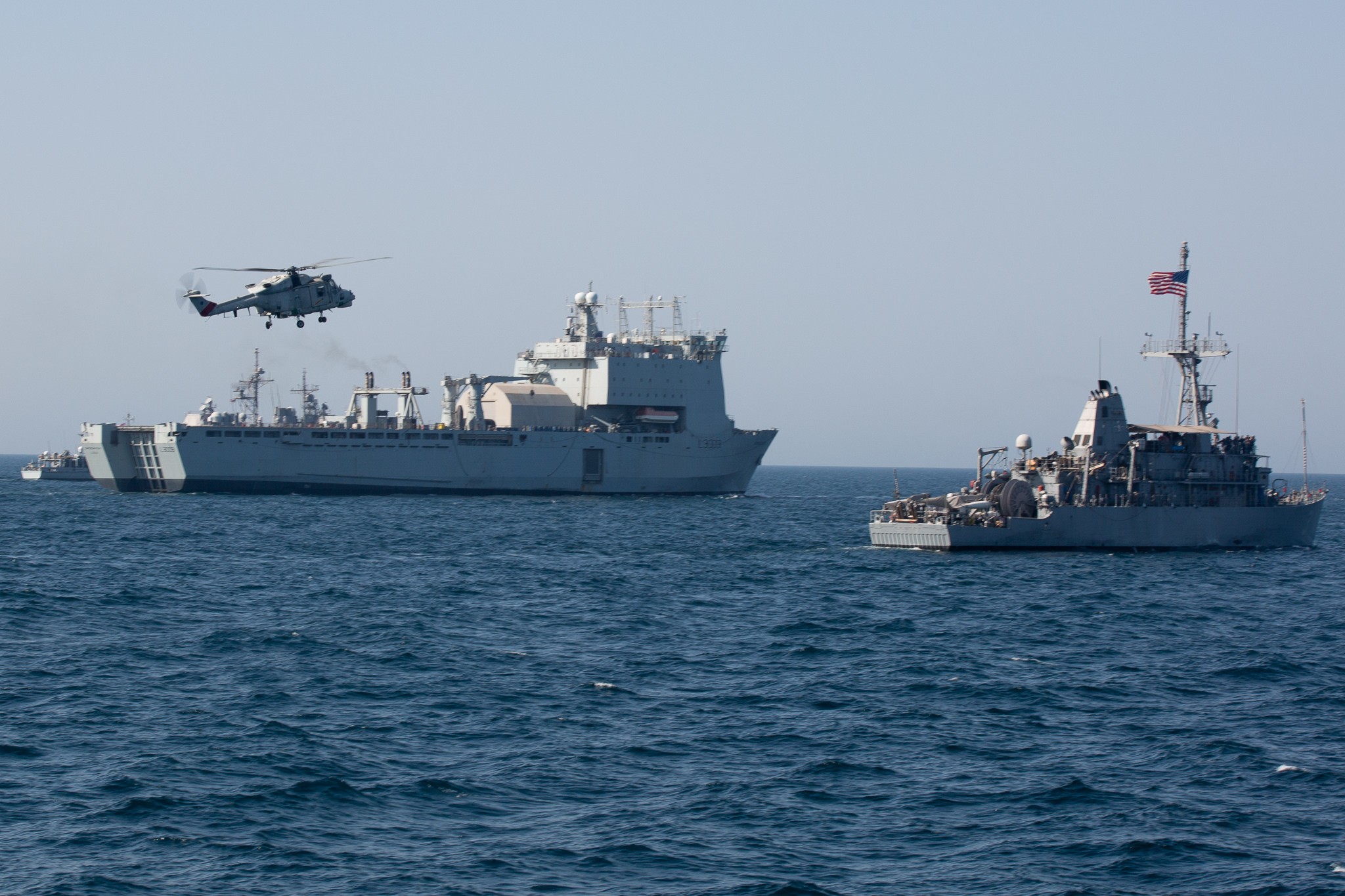 RFA Cardigan Bay mit einem US-Minensucher und einem Helikopter der omanischen Streitkräfte