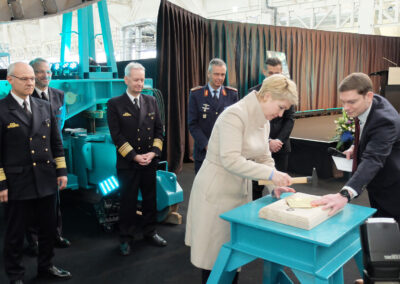 Traditionelle Kiellegungszeremonie: Ministerpräsidentin Schwesig schlägt gemeinsam mit dem Moderator den symbolischen Nagel in die Kielplatte ein. Foto: HSC