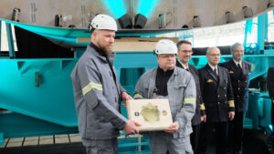 Shipyard employees present commemorative plaque: Andre Loth and Heiko Schulz show the memorial plaque installed to mark the keel laying of the new fleet service boats. Photo: HSC