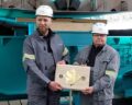 Shipyard employees Andre Loth and Heiko Schulz with the commemorative coin. Photo: hsc