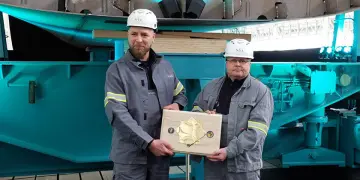 Shipyard employees Andre Loth and Heiko Schulz with the commemorative coin. Photo: hsc