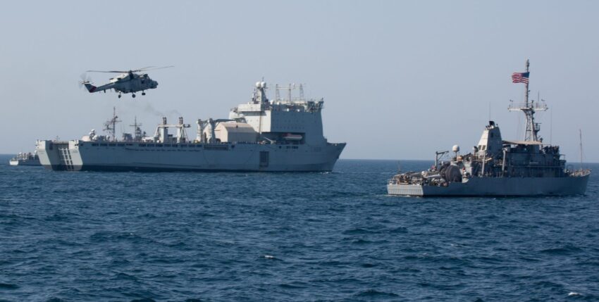 RFA Cardigan Bay mit einem US-Minensucher und einem Helikopter der omanischen Streitkräfte