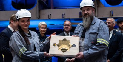 Arbeiter der Peene Werft mit der Kiellegungsplatte Foto: BMVg