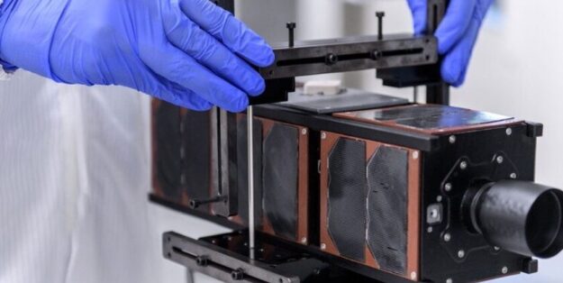 Preparing a model of the small satellite for testing. Photo: DLR