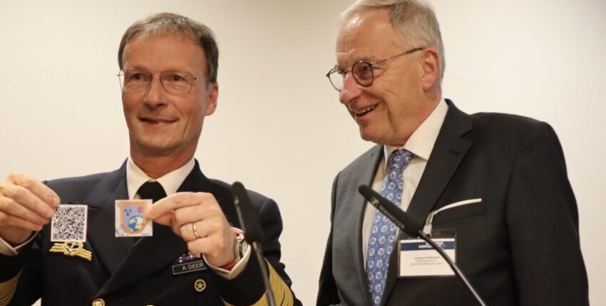 Vizeadmiral Axel Deertz (l.) präsentiert mit Konteradmiral a.D. Karsten Schneider den QR-Code zum Jahresbericht Foto: hsc